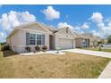 Single-story home featuring manicured landscaping and a two-car garage at 180 Grove Branch Rd, Winter Haven, FL 33880