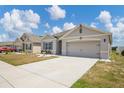 Single-story home with a driveway, neutral exterior, and manicured landscaping at 180 Grove Branch Rd, Winter Haven, FL 33880