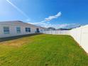 Spacious fenced backyard with lush green grass, perfect for outdoor activities and entertaining at 213 Tanager St, Haines City, FL 33844