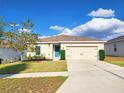 Attractive one-story house featuring a well-kept lawn and a convenient two-car garage, creating curb appeal at 213 Tanager St, Haines City, FL 33844