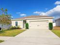 Inviting one-story home with a manicured lawn and a two-car garage, perfect for a cozy Gathering residence at 213 Tanager St, Haines City, FL 33844