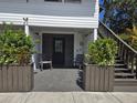 Welcoming entrance with rocking chairs and lush potted plants flanking a dark door and wooden staircase at 2222 12Th Nw St, Winter Haven, FL 33881