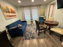Inviting living room with a blue sofa, area rug, dining table with chairs, and natural light from the windows at 2222 12Th Nw St, Winter Haven, FL 33881