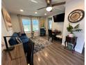 Cozy living room features a plush blue sofa, mounted TV, decorative rug, and a quaint dining area at 2222 12Th Nw St, Winter Haven, FL 33881