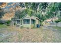 Charming cottage-style home featuring a cozy screened porch and verdant landscaping at 230 Denton Ave, Auburndale, FL 33823