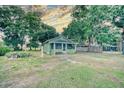 Charming cottage-style home featuring a cozy screened porch and verdant landscaping at 230 Denton Ave, Auburndale, FL 33823