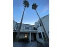 Charming condominium with a balcony and well-maintained siding and two tall palm trees in the front at 2516 Woodgate Blvd # 205, Orlando, FL 32822