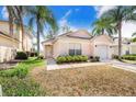 Welcoming single-story home with a well-maintained lawn, a two-car garage, and mature landscaping, perfect for families at 2960 Kokomo Loop, Haines City, FL 33844