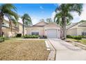 Inviting single-story home with lush landscaping, a two-car garage, and a welcoming entrance, perfect for families at 2960 Kokomo Loop, Haines City, FL 33844