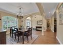 Elegant dining room with wood floors, decorative chandelier, arched doorways, and ample natural light at 3158 Beauchamp Ct, Winter Haven, FL 33884