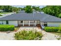 Home exterior featuring brick porch, white columns, and manicured hedges at 333 Lake Otis Se Dr, Winter Haven, FL 33880