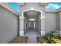 Grand covered entrance features a welcome door, gray paint, and an archway for a welcoming arrival at 3374 Waterlute Way, Lakeland, FL 33811