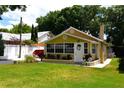 Inviting bungalow features a welcoming front porch, well-manicured lawn, and lush, colorful flower beds at 418 E 10Th Ave, Mount Dora, FL 32757