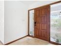 Inviting entryway with a solid wood door, tiled floors, and sidelight windows for natural light at 42 Grenewood Ln, Haines City, FL 33844