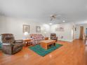 Cozy living room with hardwood floors, a ceiling fan, and comfortable seating arrangement at 4333 Shadow Wood Way, Winter Haven, FL 33880