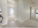 Inviting hallway with tiled flooring leading to a room with a carpeted floor and bright natural light at 4480 Turnberry Ln, Lake Wales, FL 33859
