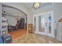 Inviting foyer featuring tile flooring, decorative front doors, and an arched doorway leading to other rooms at 4703 Benton St, Lake Wales, FL 33859