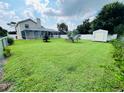 Large backyard with screen enclosed patio, privacy fence, and mature landscaping at 502 Little Lake Ct, Winter Haven, FL 33884