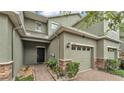 Charming townhome featuring a one car garage and inviting brick paver entry walkway, with lush landscaping at 6343 Torrington Cir, Lakeland, FL 33811