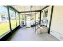Enclosed lanai, perfect for enjoying the outdoors, furnished with chairs and a table at 6562 Chinaberry Ne Dr, Winter Haven, FL 33881