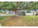 A beautiful shade tree stands tall in the front yard, and the property is surrounded by a privacy fence at 7120 Summit Dr, Winter Haven, FL 33884