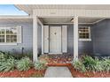 Charming front door with decorative accents and a mosaic tiled porch, surrounded by lush landscaping at 1010 Biltmore Nw Dr, Winter Haven, FL 33881