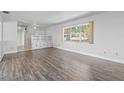 Bright living room features wood-look flooring, built-in storage, and a large window at 1010 Biltmore Nw Dr, Winter Haven, FL 33881