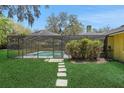Screened-in pool with stone pavers and lush landscaping providing a private outdoor oasis at 1226 Lake Loop, Winter Haven, FL 33880