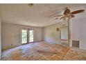 Bedroom featuring a ceiling fan, and double doors offering natural light, with a glimpse into the next room at 1294 1/2 38Th Nw St, Winter Haven, FL 33881