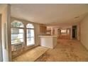 Spacious living room with large windows providing ample natural light and a breakfast bar separating the kitchen area at 1294 1/2 38Th Nw St, Winter Haven, FL 33881