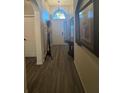 Foyer featuring neutral walls, wood flooring, and arched window for a bright entry at 135 Minniehaha Cir, Haines City, FL 33844