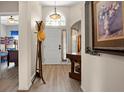 Welcoming foyer with arched window above the front door and handsome wood floors with views to other rooms at 135 Minniehaha Cir, Haines City, FL 33844