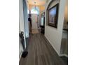 Hallway featuring art display and wood look floors leading to the front door at 135 Minniehaha Cir, Haines City, FL 33844