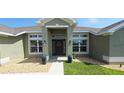 Charming front entrance with a decorative wreath, complemented by elegant outdoor lighting and tasteful landscaping at 1400 Eagle Crest Blvd, Winter Haven, FL 33881