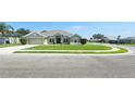 Inviting front yard with a well-maintained lawn, featuring a driveway and charming curb appeal in a neighborhood setting at 1400 Eagle Crest Blvd, Winter Haven, FL 33881