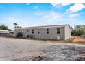 Rear view of a one-story home featuring gray siding and plenty of windows at 1499 32Nd Nw St, Winter Haven, FL 33881