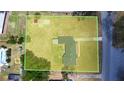 Aerial view of the property showcasing the expansive lot size with a home, driveway, and surrounding landscape at 1515 W Lake Cannon Nw Dr, Winter Haven, FL 33881