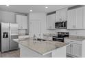 Modern kitchen with stainless steel appliances, granite countertops, and white cabinetry at 1752 Forest Run Ln, Auburndale, FL 33823