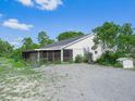 Backyard of this house featuring a screen-in patio and a gravel-covered yard at 1850 S Lake Reedy Blvd, Frostproof, FL 33843