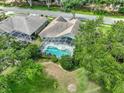 Backyard aerial view featuring a screened-in pool, lush lawn, and well-maintained landscaping at 1902 Southern Dunes Blvd, Haines City, FL 33844