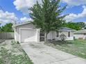Charming single-story home with attached garage, mature tree, and well-maintained front yard at 2100 Magnolia Ave, Haines City, FL 33844