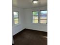 Bedroom with white walls, brown carpet, and natural light from two windows at 217 Nw 4Th Ave, Mulberry, FL 33860