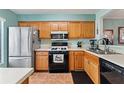 Kitchen with wood cabinets, tile flooring, and stainless steel appliances at 2180 San Marcos Se Cir # 401, Winter Haven, FL 33880