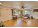 Bright living room with large bay window, laminate floors, and a cozy seating area at 230 W Harbord St, Lake Alfred, FL 33850