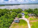 Stunning aerial view showcases the lakefront property with lush greenery and multiple buildings at 250 Brigham Nw Rd, Winter Haven, FL 33881