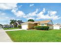 Well-kept single-story home with lush green lawn, attached garage, and manicured shrubbery at 251 Kings Pond Ave, Winter Haven, FL 33880