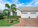 Villa with a two-car garage, brick paved drive and beautiful landscaping at 2824 Attwater Loop, Winter Haven, FL 33884