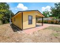 Bright yellow home with dark trim, showcasing a quaint covered porch at 305 Armour Ave, Auburndale, FL 33823