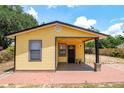 Inviting yellow home showcasing a welcoming front porch and tidy front yard at 305 Armour Ave, Auburndale, FL 33823