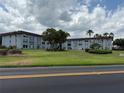 Exterior shot of the complex, with large trees on a well-maintained lawn at 333 Lake Howard Nw Dr # 103C, Winter Haven, FL 33880